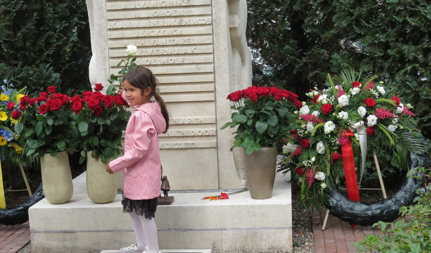 De vijfenhalfjarige Jasmijn van Dijk van de derde generatie plaatst een witte roos tussen de rode rozen. 