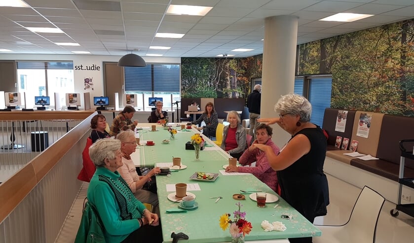 Gastvrouw Dorine (r) in gesprek met deelnemers aan de Voorleeslunch.