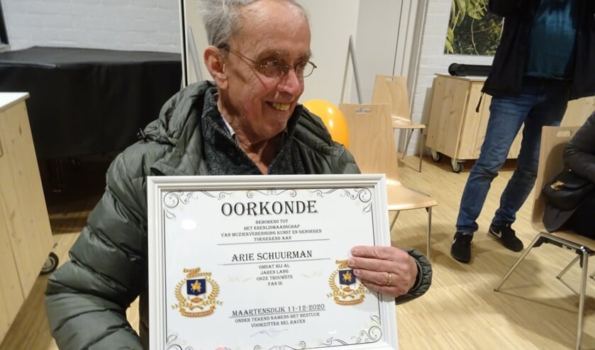 Vol trots poseert Arie Schuurman met de oorkonde van het erelidmaatschap die hem zojuist door de voorzitter is uitgereikt.
