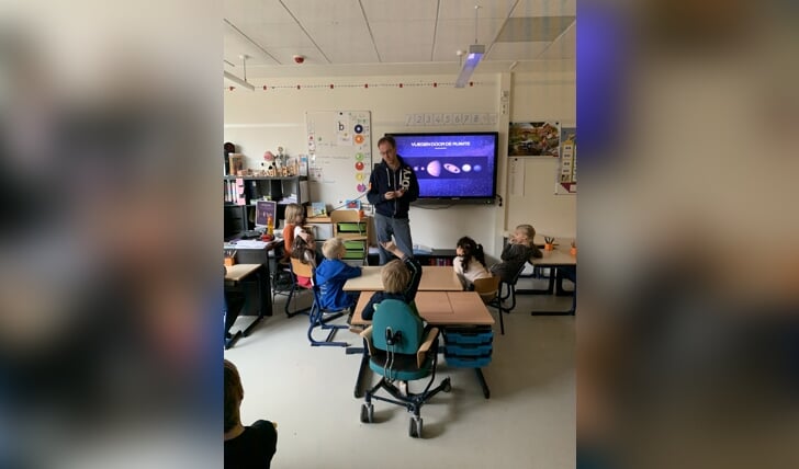 Een ouder geeft in groep 3 een zelfgemaakte les over vliegen door de ruimte.