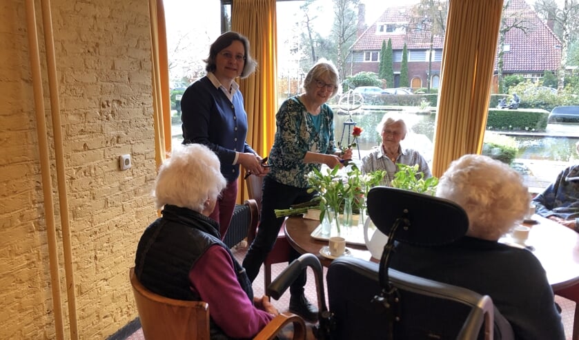 Martine Pol (staand links) van Lionsclub Utrecht Kromme Rijn overhandigde 11 maart het bedrag aan Marlies Dijkkamp (rechts) van Wooncentrum Schutmantel en zette de eerste bloemen op tafel.