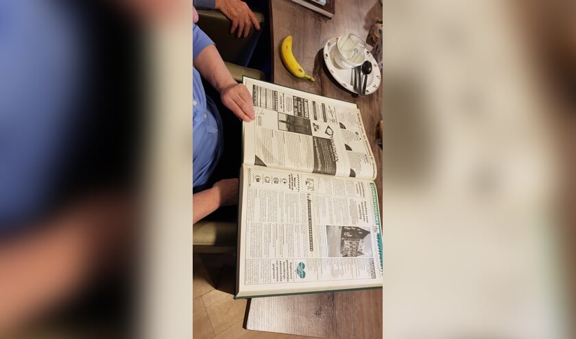 In de woonkamer van Huize Het Oosten lezen bewoners oud nieuws terug.