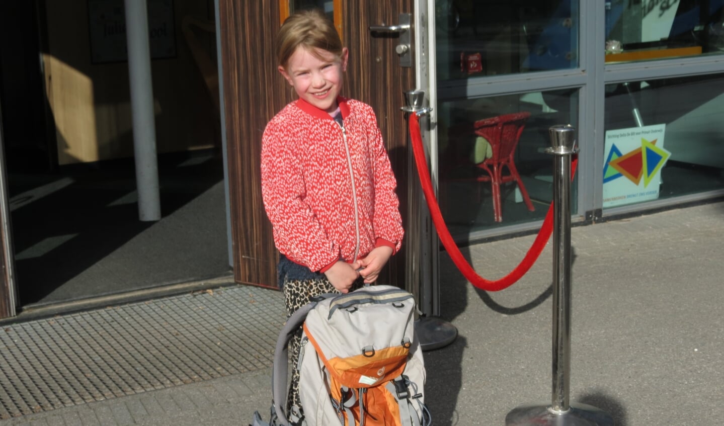 Jasmijn gaat met een grote tas de school in.