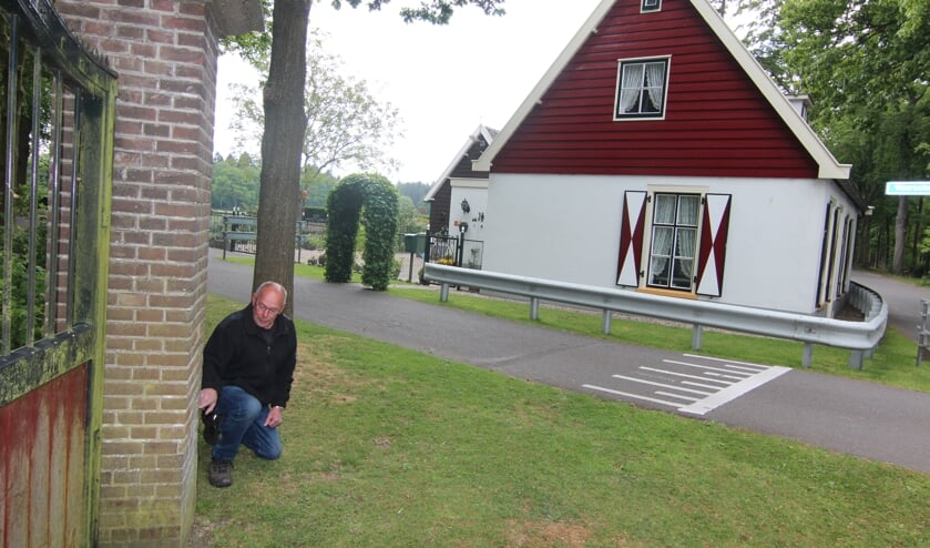 Henk Kuus wijst op het ingangshek de plek aan de stenen hoekpaal af brak. Op de achtergrond zijn geboortehuis Het Tolhuis.