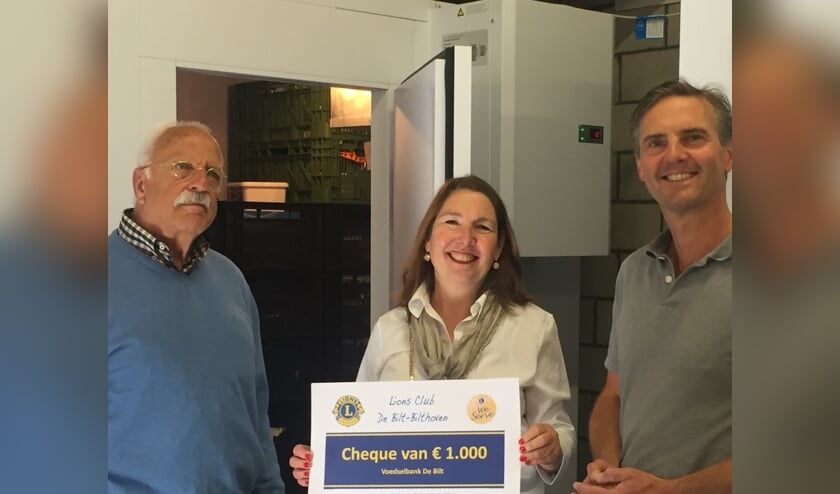 Voorzitter van de Voedselbank, Jolanda van Hulst, staat met de heren Lindenbergh (l) en van Driel (r) van de Lionsclub De Bilt Bilthoven voor de koelinstallatie.   