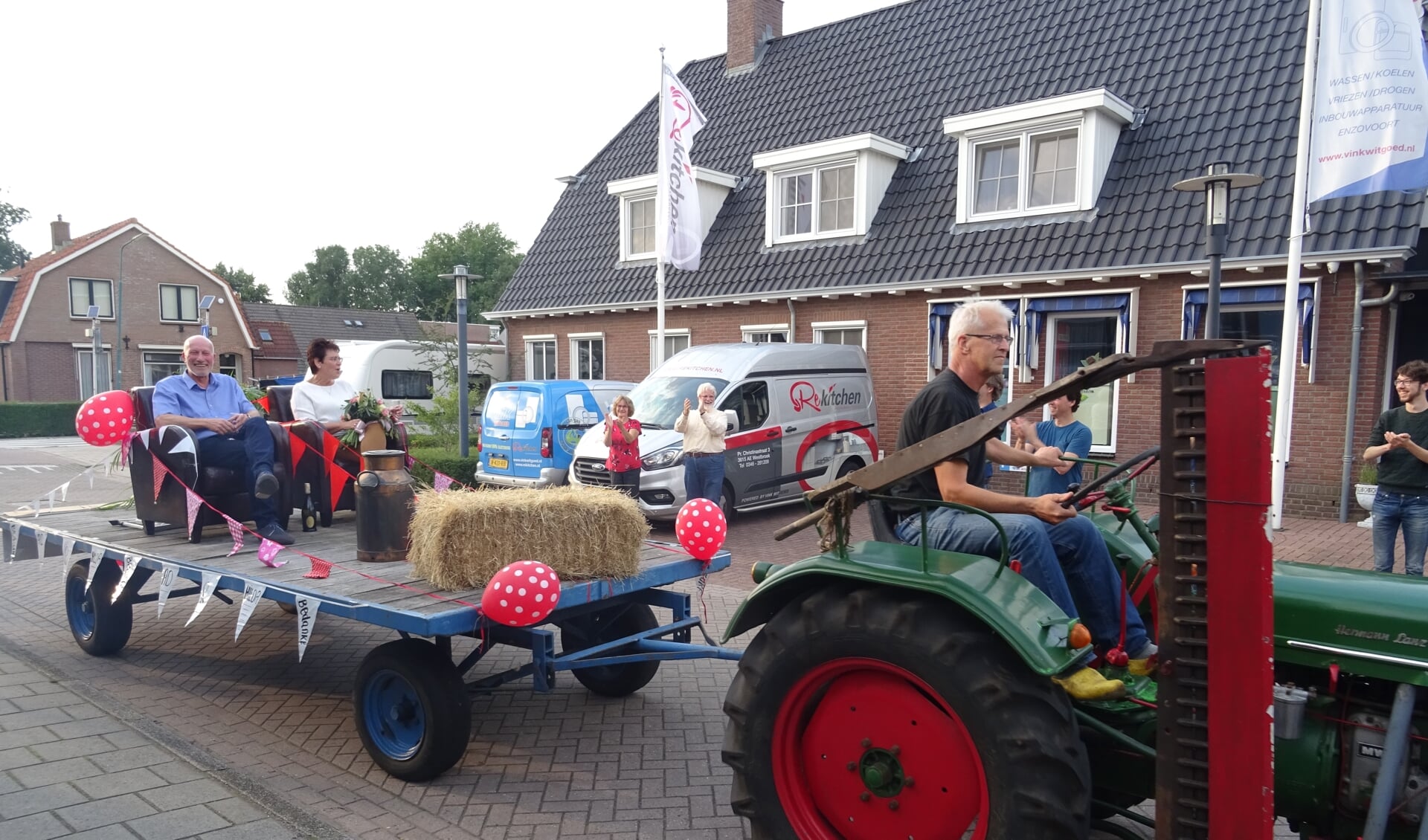 Ad en Hilda krijgen een ererondje op de platte kar door het dorp.