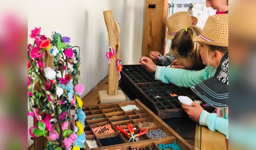 Kinderen kiezen materialen voor Ibiza armbandjes. (foto Hip and Happy events)