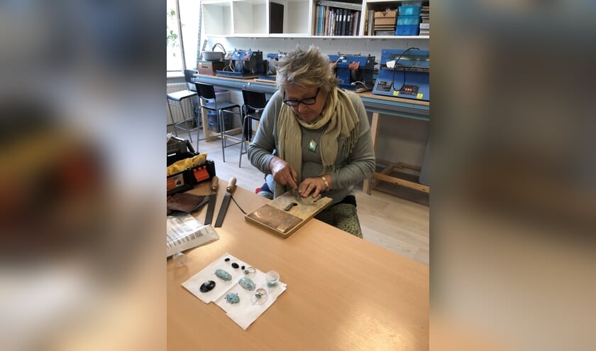 Marga Langenkamp is bezig een zelfgemaakte zilveren ring te vijlen zodat deze mooi glad wordt.