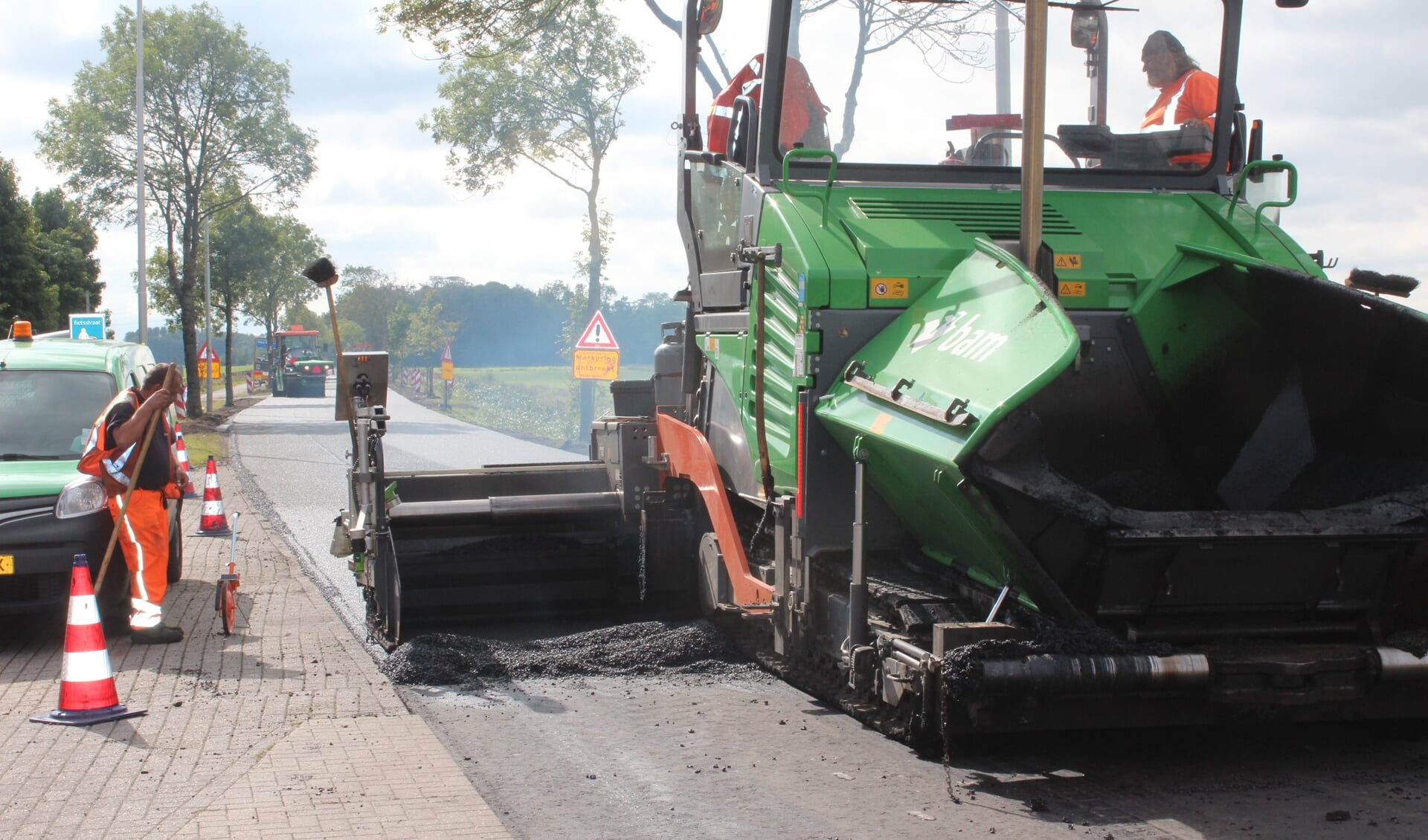 Een asfaltmachine legt een laag klaar voor verwerking ter hoogte van de Brandweergarage Maartensdijk.