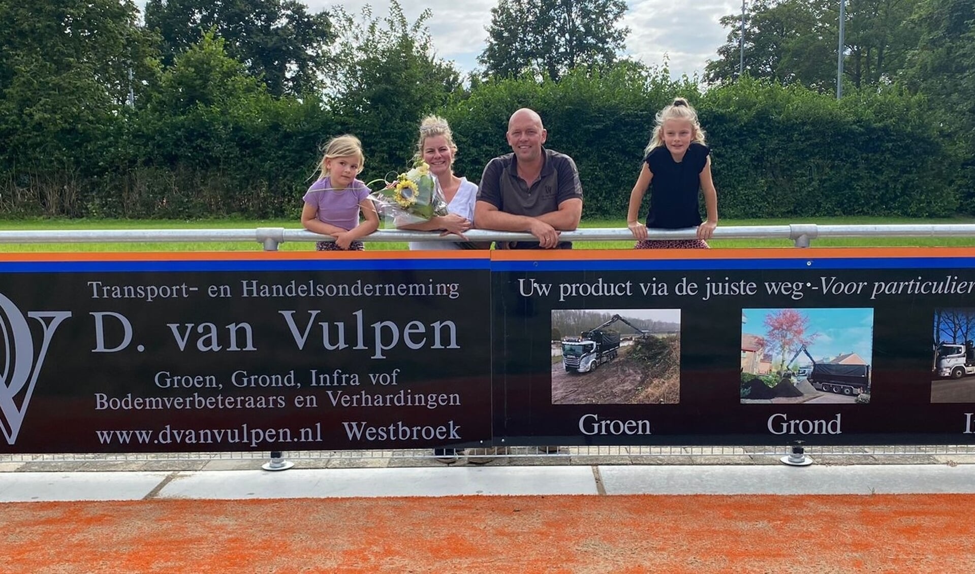 Dirk en Anette van Vulpen met hun beide dochters bij de twee borden.