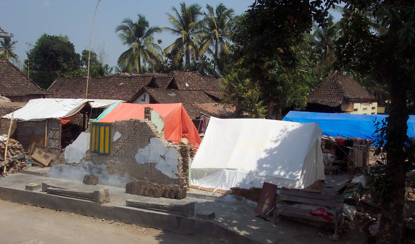 Na de aardbeving leefden veel mensen in tenten tussen de restanten van hun woningen.