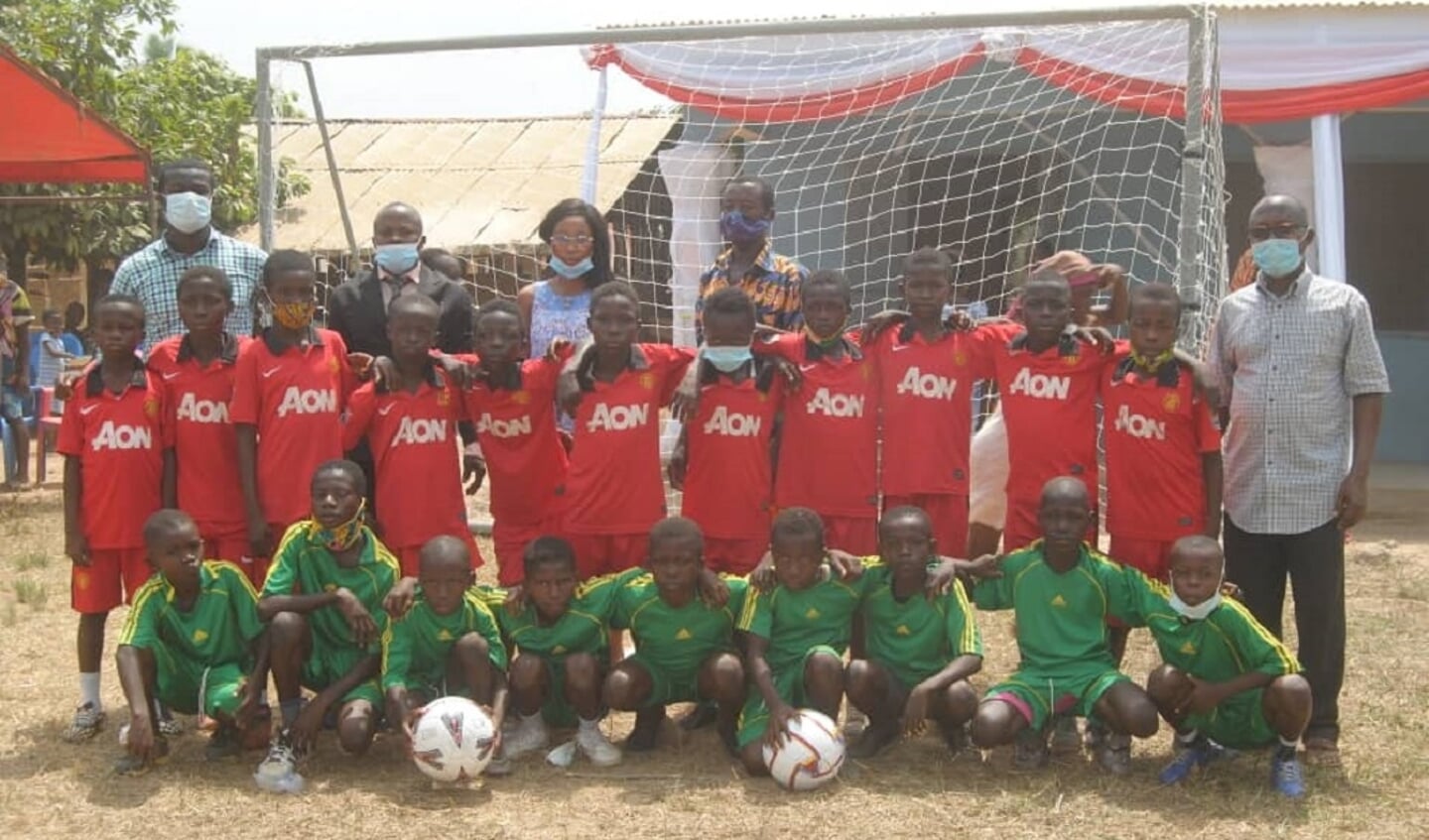 Ghanese kinderen poseren graag voor de nieuwe goals in hun nieuwe shirts. Rechtsboven op de achtergrond staat het nieuwe kleutergebouw.

