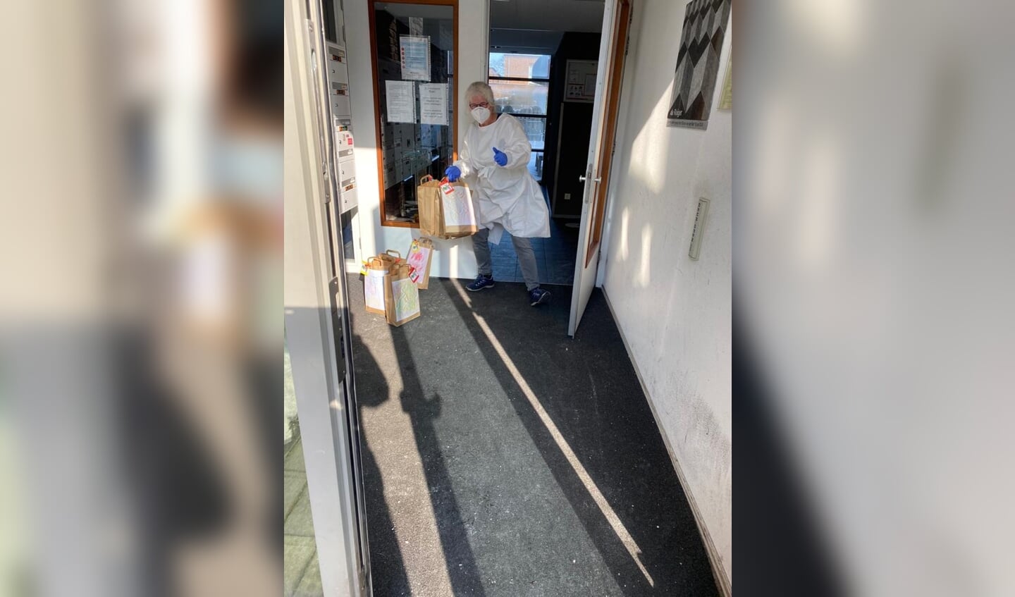 Een medewerker van De Reiger (Reinaerde) pakt namens de Kroegbezoekers de tasjes aan. Vanwege besmettingen en quarantaine is voorzichtigheid geboden, maar een carnaval vieren gaan ze wel doen.