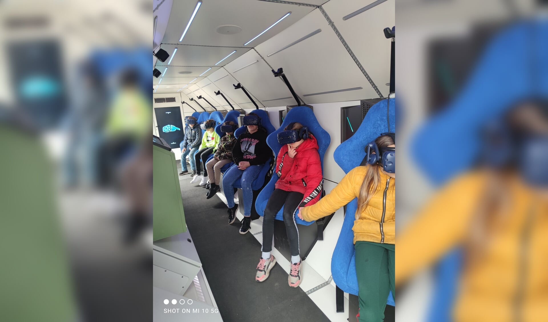 In de stoelen met de virtualrealitybrillen op ervaren de kinderen hoe het is om door de ruimte te vliegen.