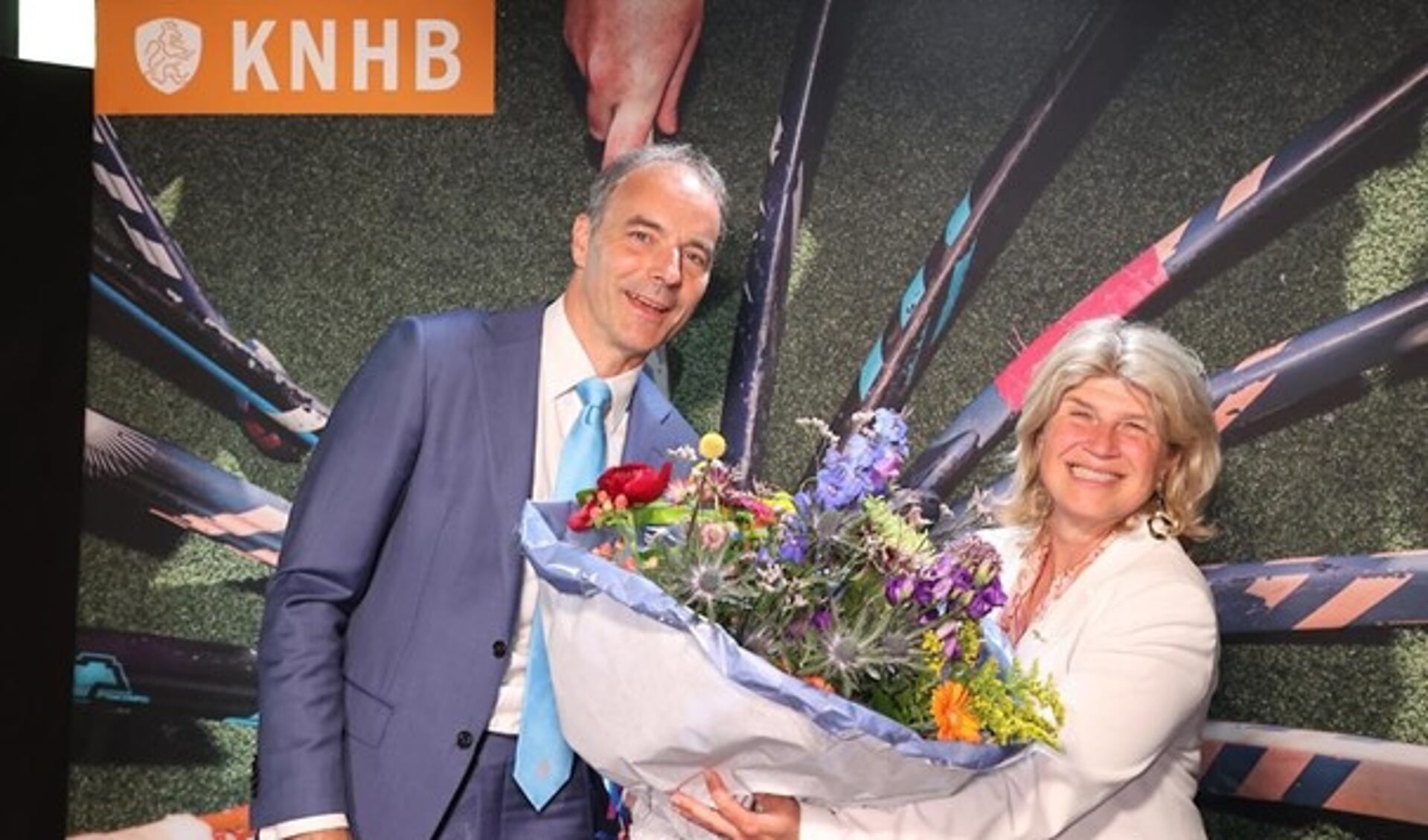 Voorzitter Erik Cornelissen overhandigt Madeleine Bakker een prachtige bos bloemen nadat zij benoemd is tot erelid van de KNHB.