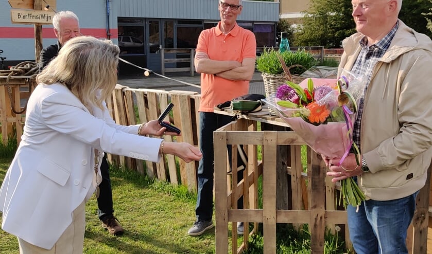 Na de bloemen overhandigt de locoburgemeester met een diepe buiging de chapeau-penning aan Ron Smit.