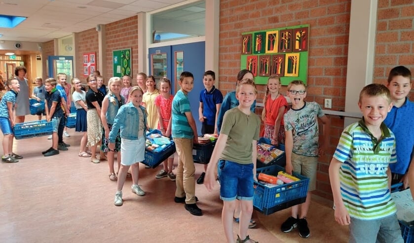 De leerlingen ielpen graag met het sjouwen van de gevulde kratten.