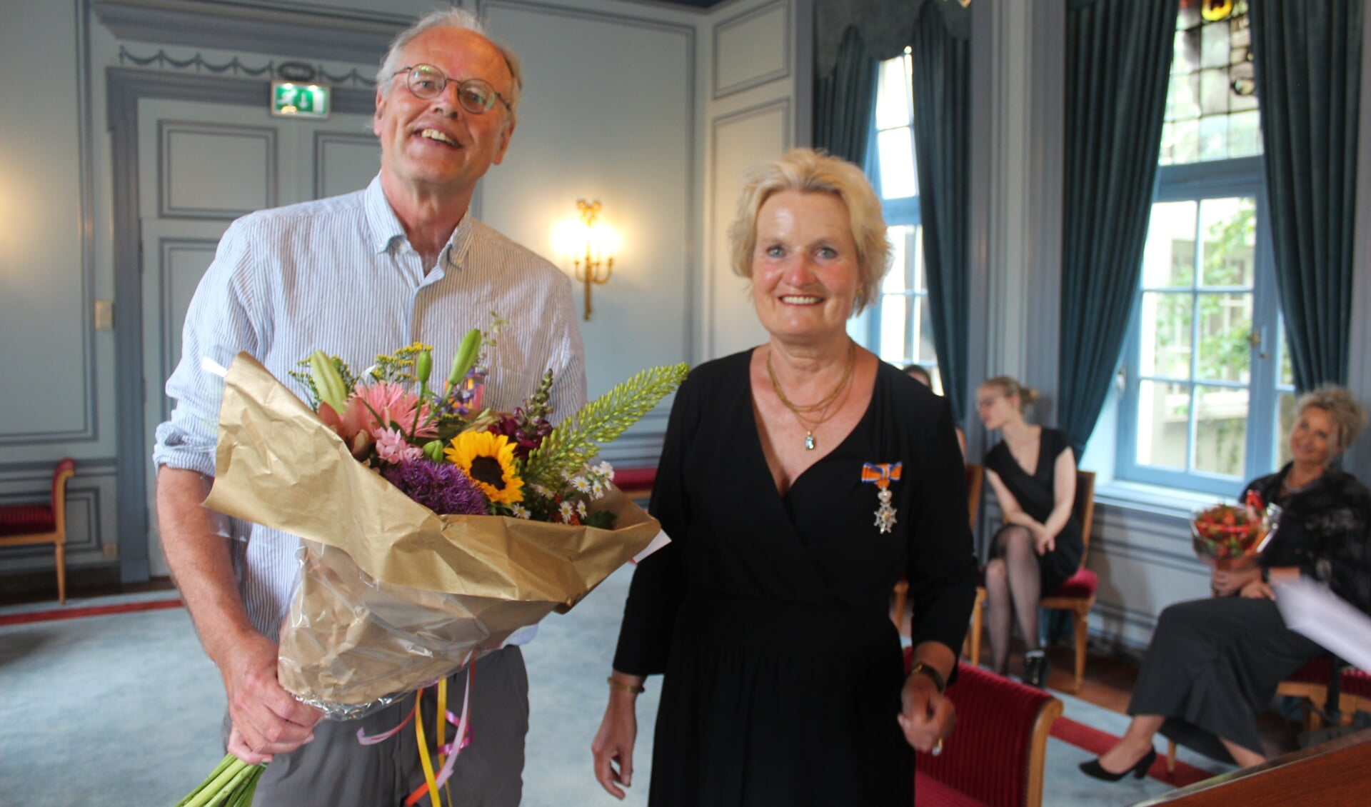 Op verzoek van burgemeester Sjoerd Potters speldde haar man (links) de onderscheiding op. [foto Henk van de Bunt]