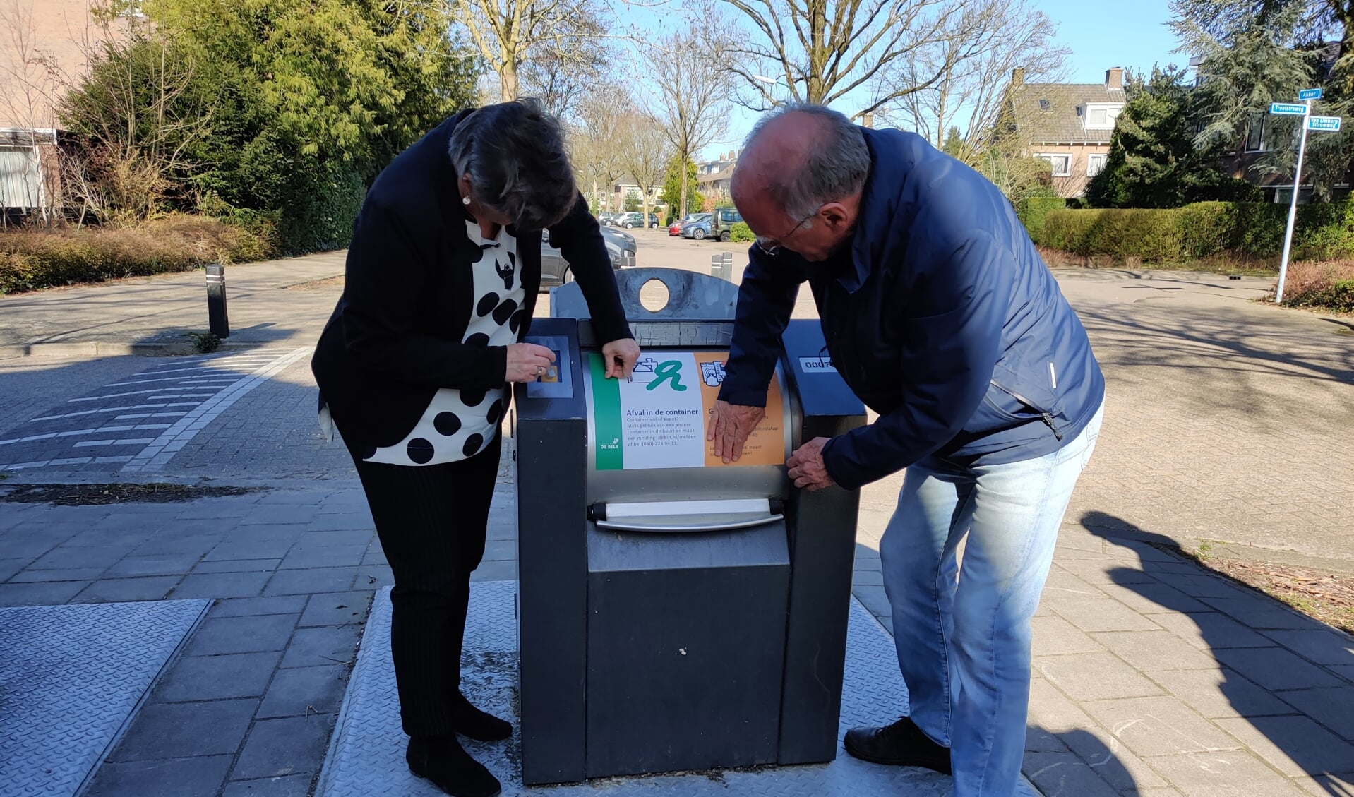 De eerste sticker werd donderdag 17 maart door de wethouder en een vertegenwoordiger van de wijkvereniging op de container op de hoek Akker/Troelstraweg in De Bilt geplakt.