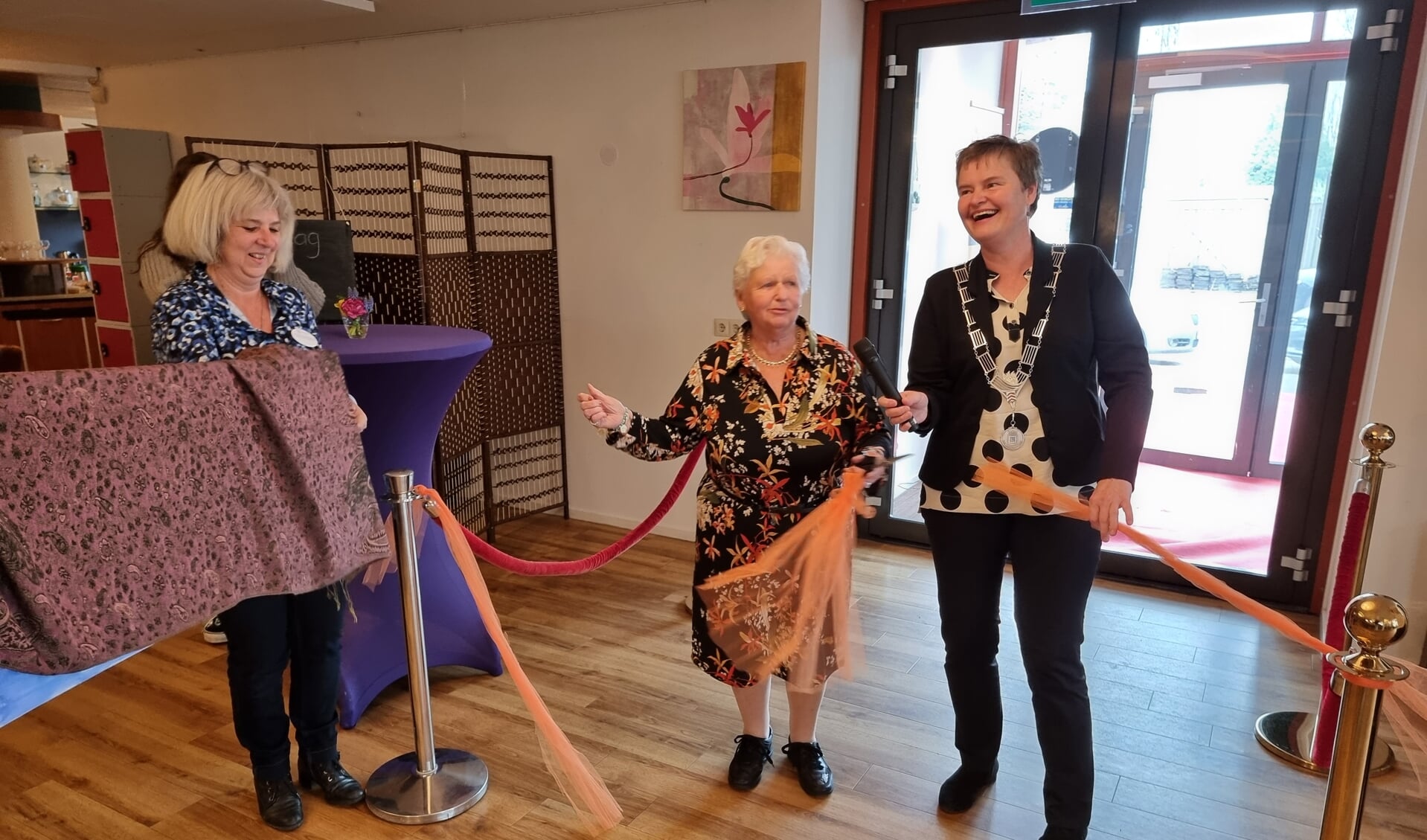 Samen met één van de deelnemers opent locoburgemeester Anne Brommersma het nieuwe ontmoetingscentrum.