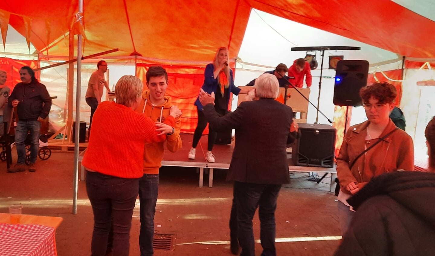 Zangeres Joyce Geurtsen treedt op in de feesttent terwijl enkelen zich aan een dansje wagen.