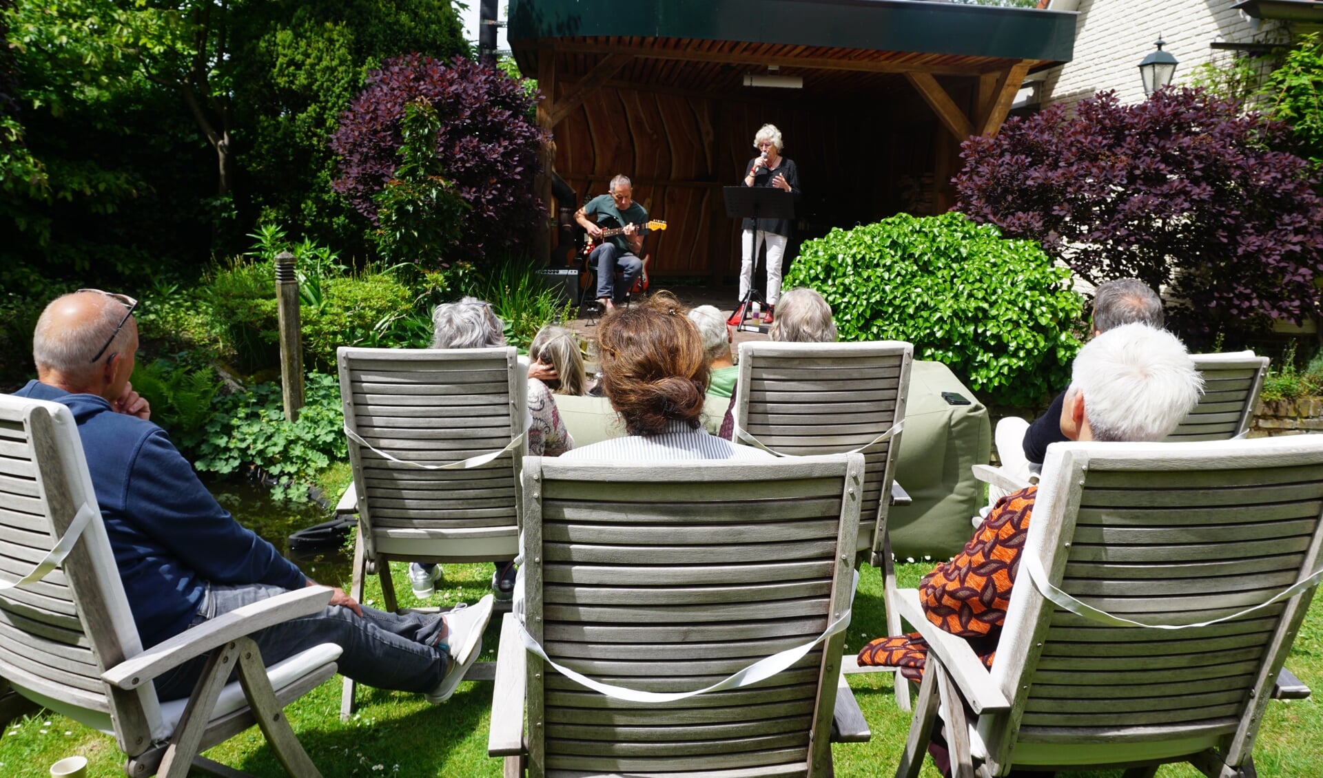 In de zonovergoten achtertuin zingt Andrea Hessing begeleid door Paul Deneer.