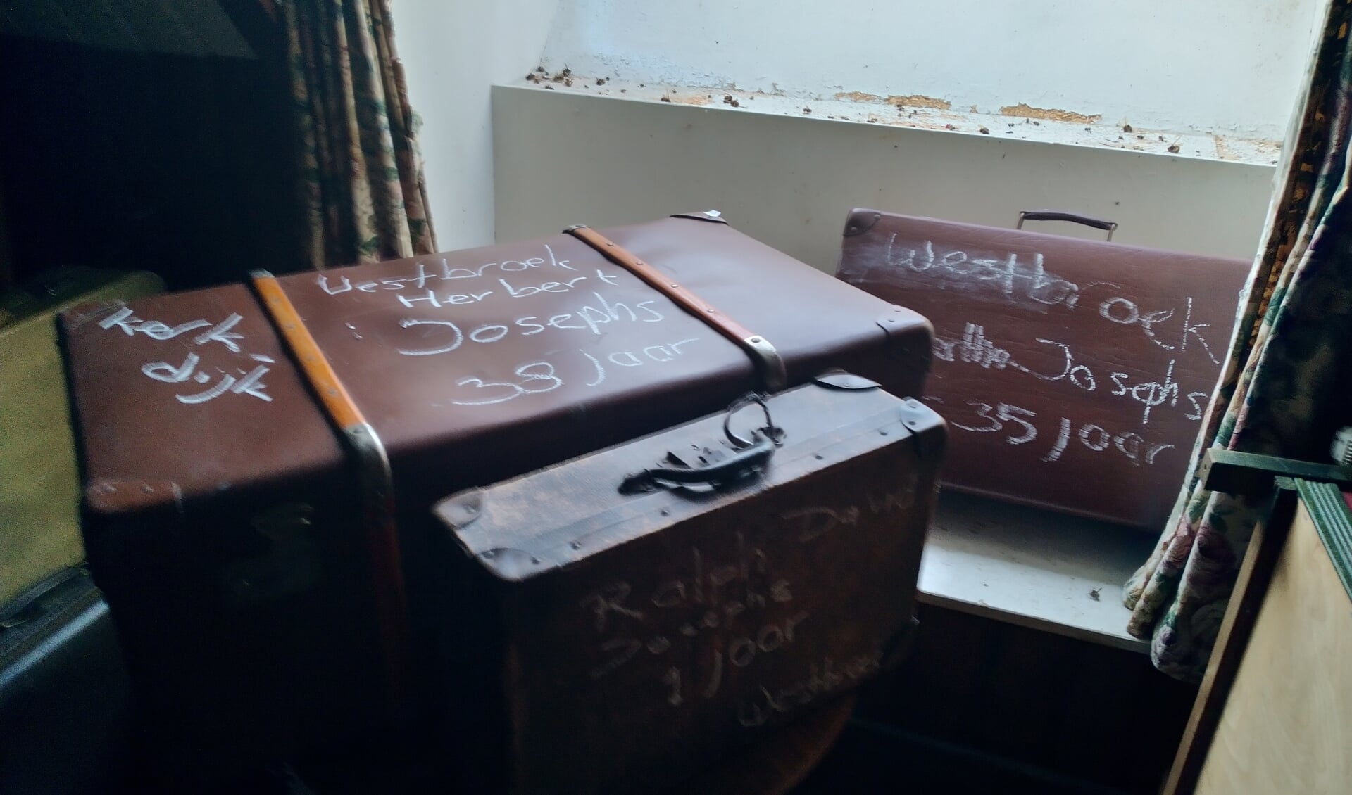 Het hart van de tentoonstelling zijn koffers met daarop de namen en leeftijden van de vermoorde Joodse inwoners.