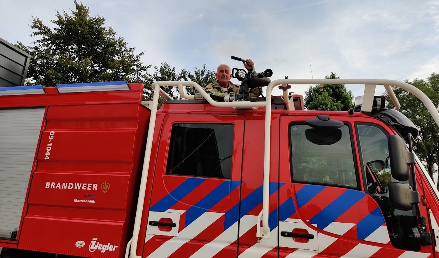 Freek de Graaf staat door het dakluik van de cabine van een voertuig dat speciaal is ontworpen om natuurbranden te bestrijden.