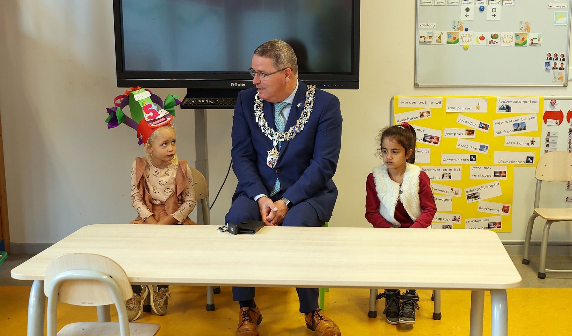 Burgemeester Marcel Delhez met Bliss en Esrah uit groep 1/2A. FOTO: Bert Jansen.