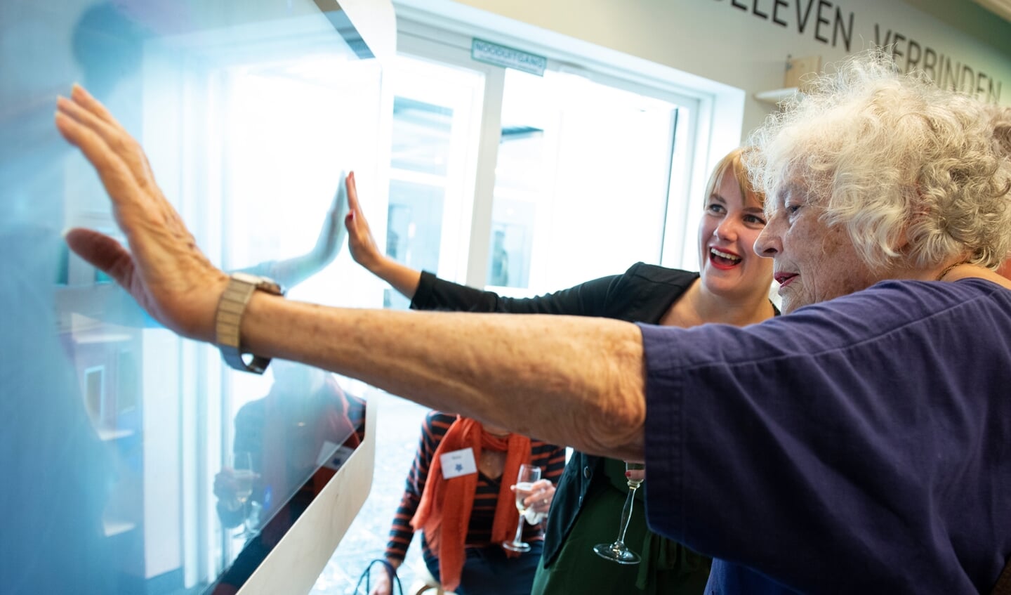 Imke Duijf van de Bibliotheek demonstreert de belevenistafel aan schrijfster Marjan Berk tijdens de opening van de Dementheek.FOTO: Willem Binnendijk.