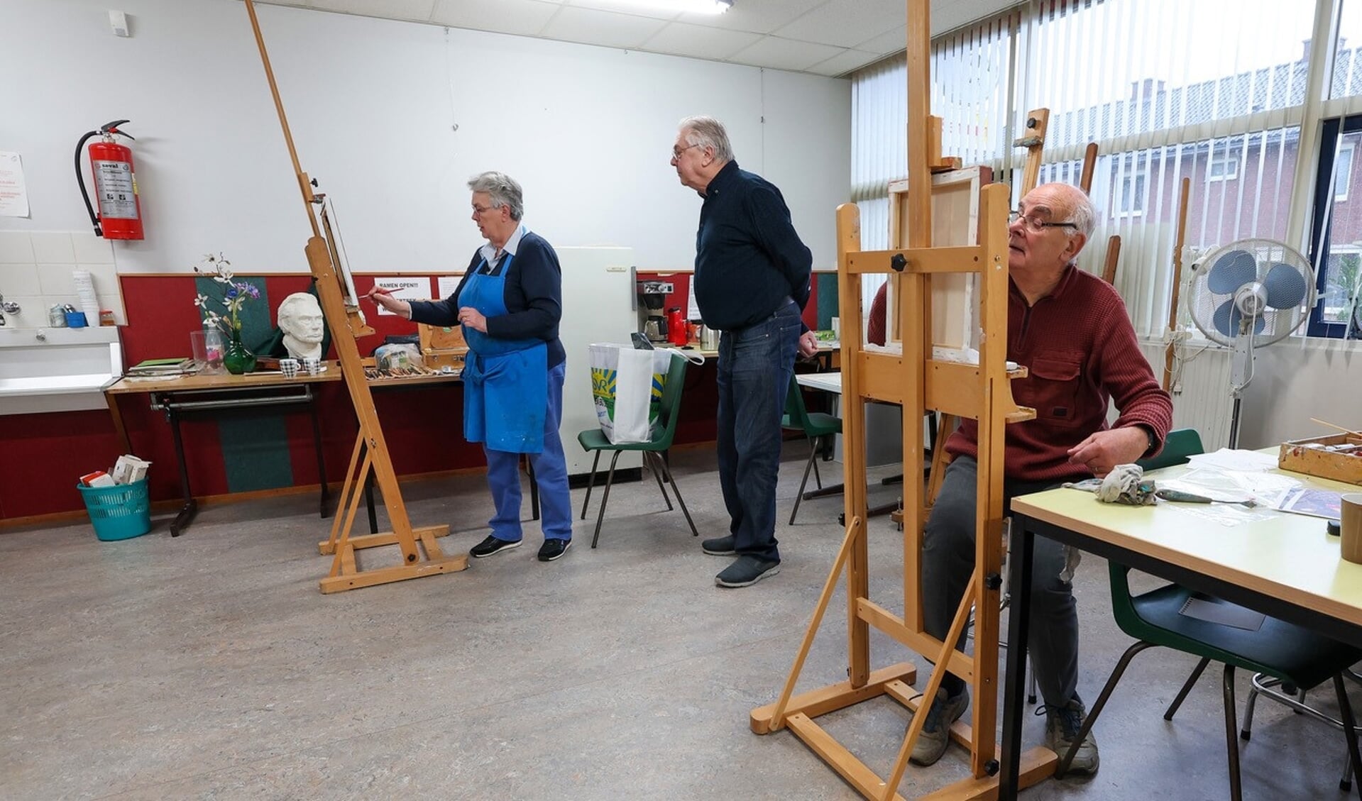 Amateurschildervereniging het Penseeltje bestaat veertig jaar. Op de achtergrond schildert voorzitter Els Rijnvis. FOTO: Bert Jansen.