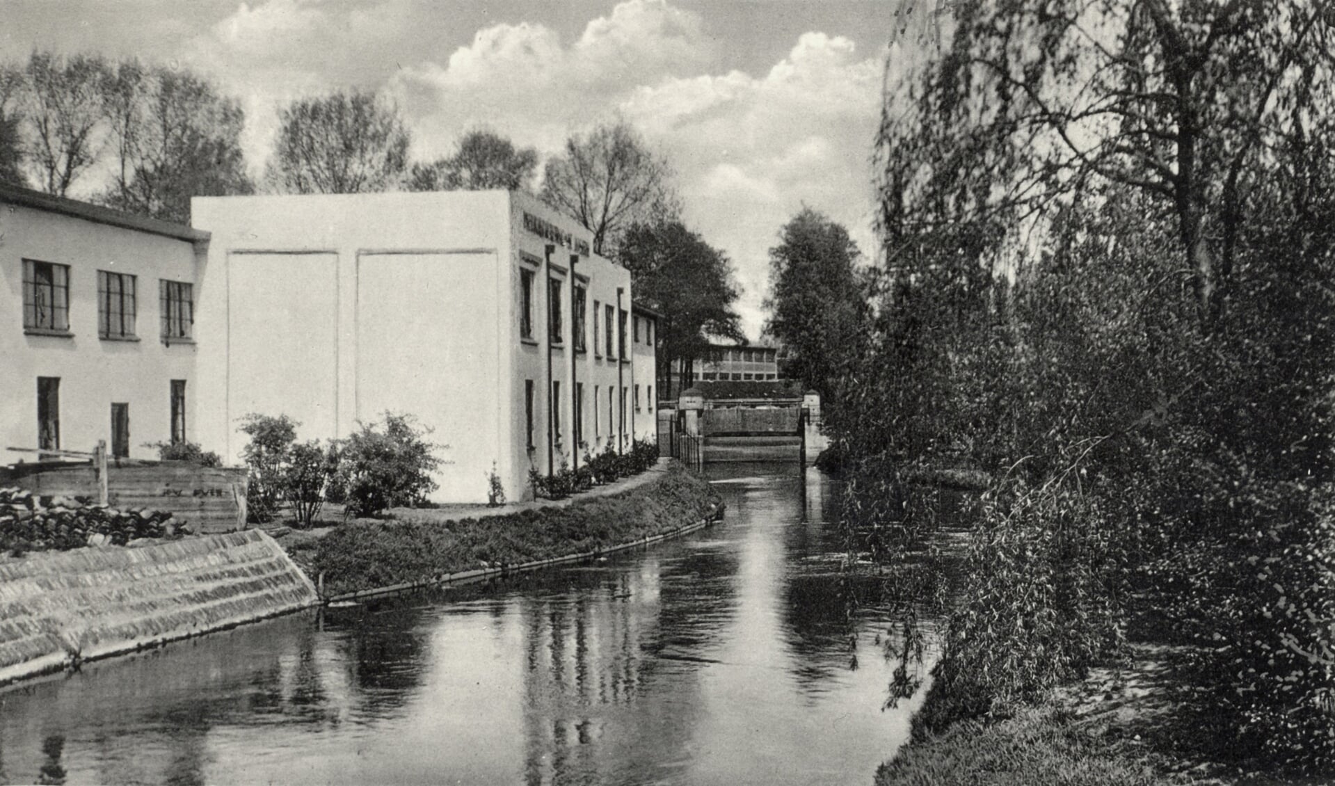 De achterzijde van de melkfabriek Sint Joseph en verderop de stuw bij de Walbrug in 1936. FOTO: Eindhoven in Beeld.