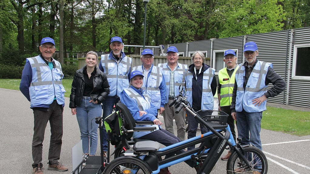 Geschaard achter de laatste Nuenense aanwinst, een elektrische rolstoelfiets, de deelnemende Fietsmaatjes. Tweede van links: organisator Gwen van der Weijden.