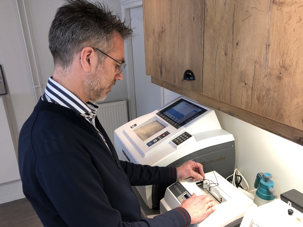Opticien en optemetrist Arnold Berghorst Arnold is een bril aan het tracen voor een spoedbestelling.