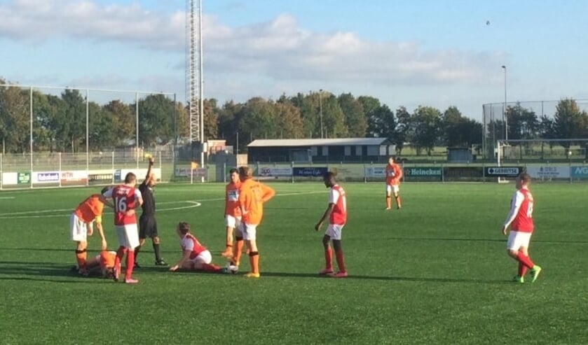 Linkermiddenvelder Tim Clements krijgt terecht geel na gevaarlijk gestrekt inkomen.