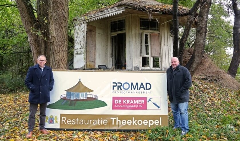 Wethouder Bert Vermeij (l) en Rob Stekelenburg (Promad) markeren de restauratie van de theekoepel aan de Papenhoef bij het onthulde bouwbord. Foto: Alex de Kuijper