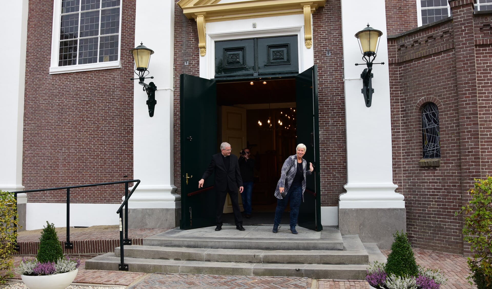 • Met het openen van de kerkdeuren door pastoor Van der Mee en wethouder Blok werd de gerestaureerde St. Barnabas officieel opgeleverd. (foto: Adri Verhoeven)