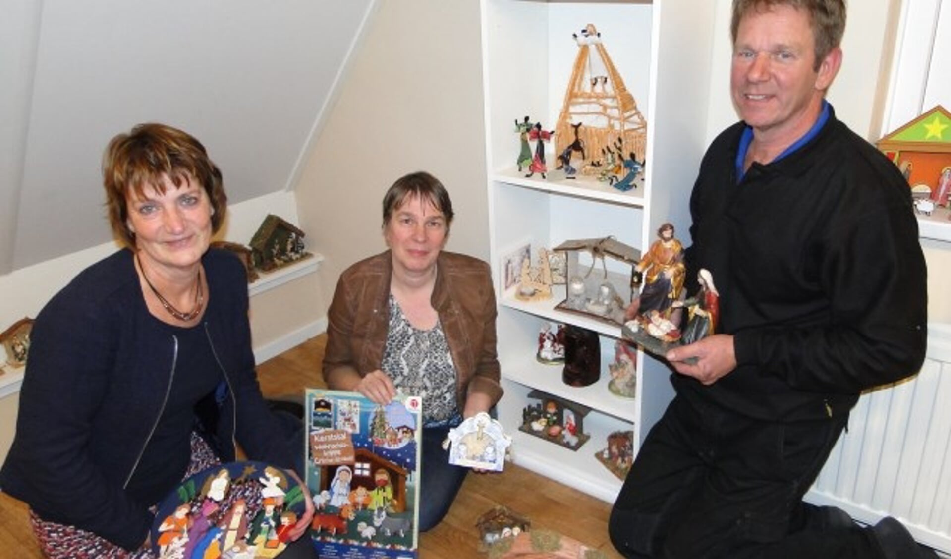Van links naar rechts: Elly de Wit, Miranda Hoogenboom en Kees van Vliet te midden van de kerststalletjes. (Foto: Margreet Nagtegaal)