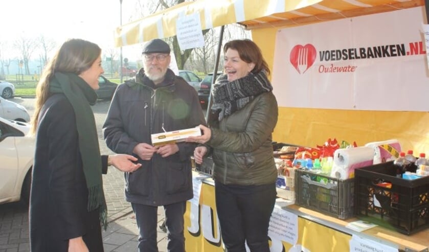 Vader en dochter zamelen producten in, die zij extra in de voedselpakket kunnen stoppen. (Foto: Sophie Meijer)