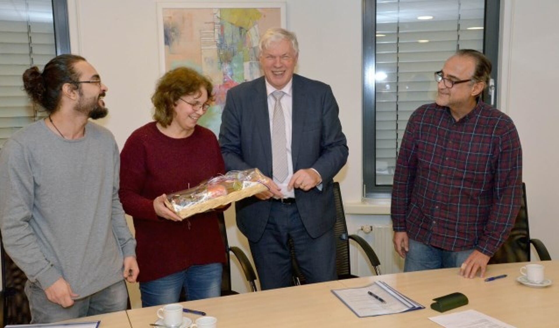 Het Syrische gezin krijgt na de ondertekening van wethouder Jan Vlaar een mandje met streekproducten. (Foto + tekst: Paul van den Dungen)