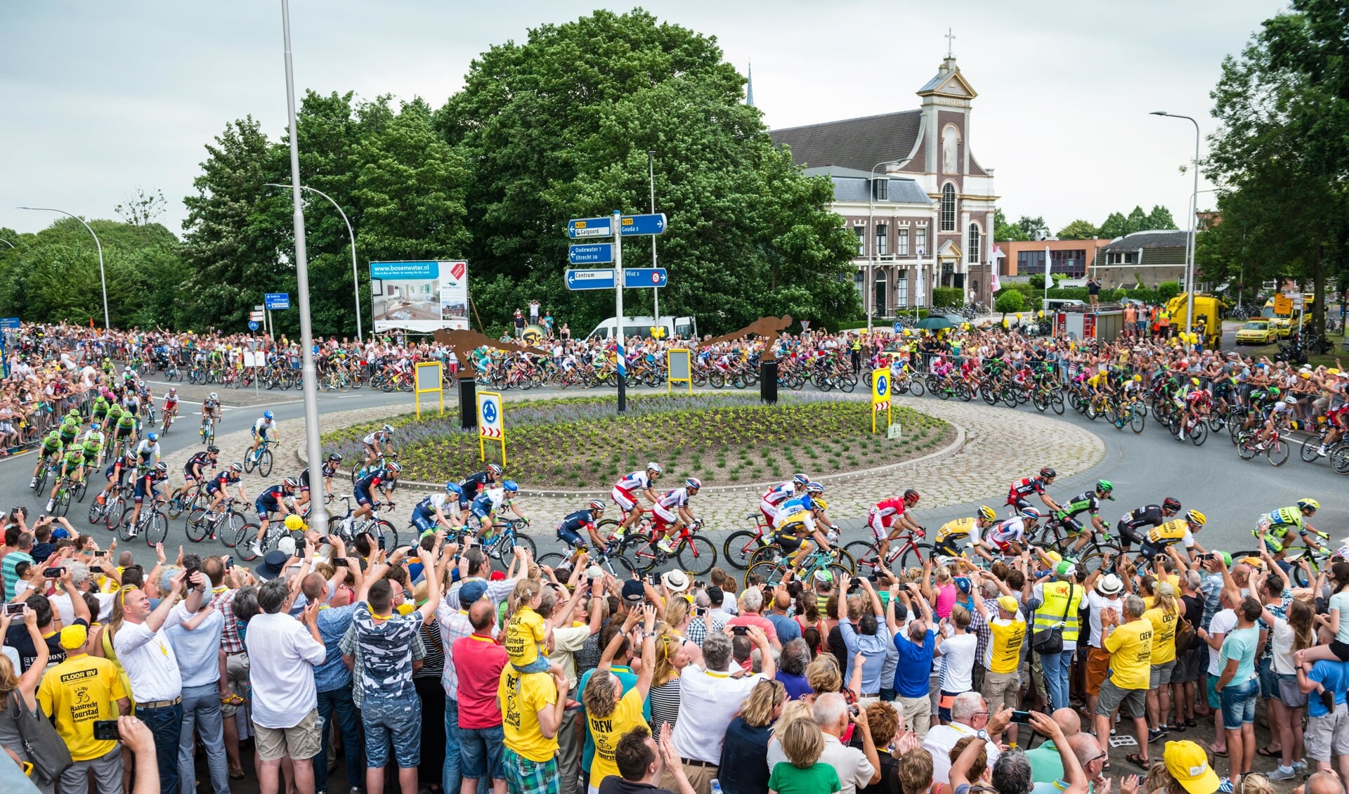 • Het langgerekte Tourpeloton passeert in 2016 de rotonde te Haastrecht, gadegeslagen door duizenden toeschouwers.