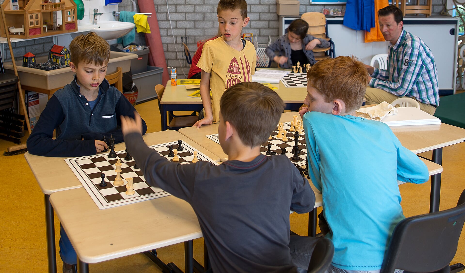 • Herbert Eppinga (r) tussen een aantal schakers van obs De Springplank.