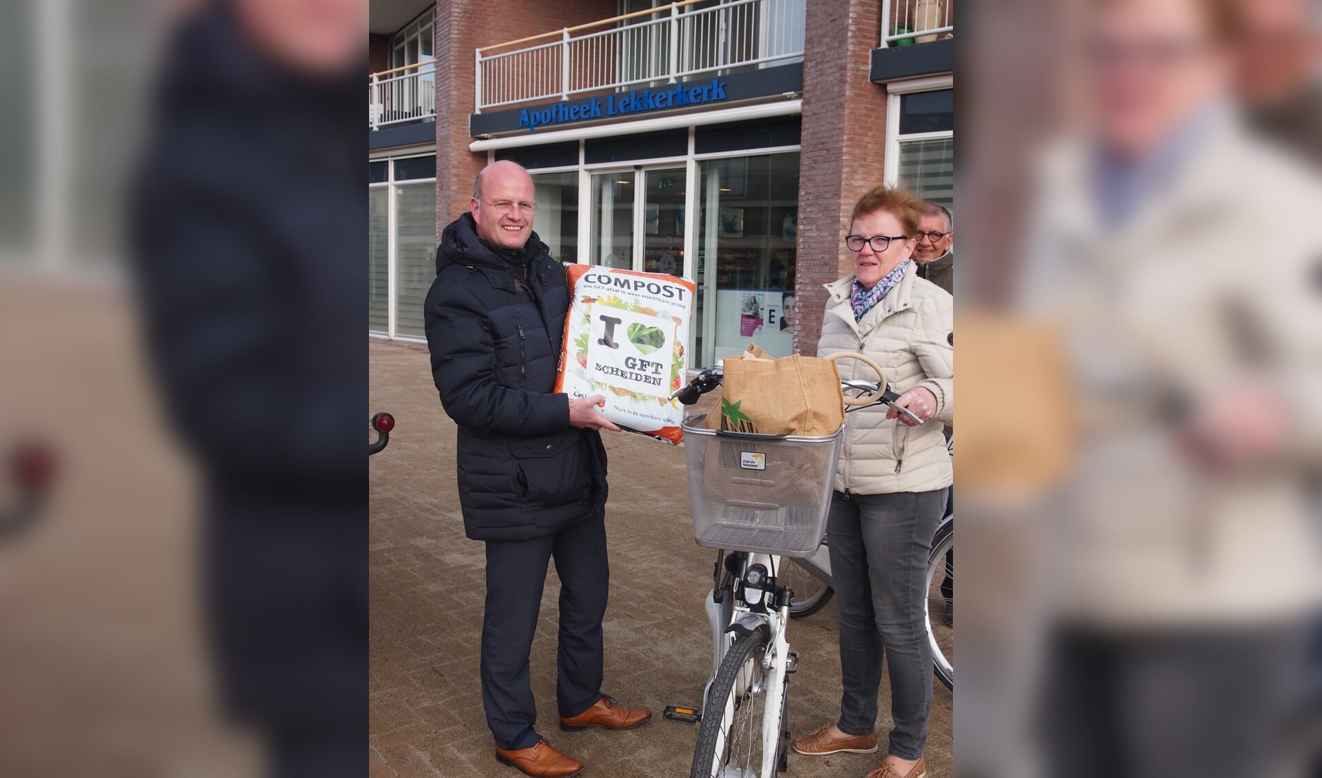 • Wethouder Pieter Neven deelt gratis compost uit op de weekmarkt in Lekkerkerk. (foto: gemeente Krimpenerwaard)