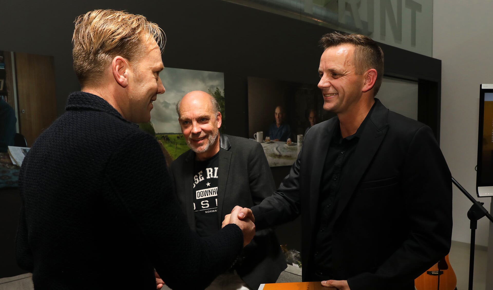 • Joost-Jan Kool (l) overhandigt de eerste exemplaren aan Bram van der Wal en Ferry Verheij.