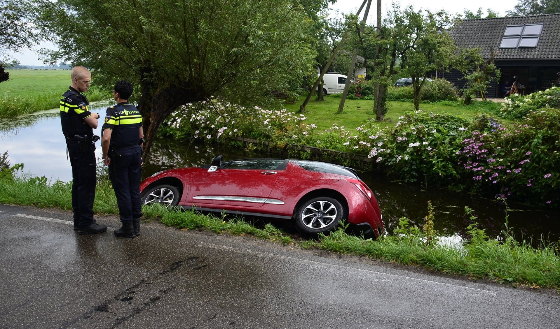 • Na een hevige regenbui belandde de auto deels in de sloot.