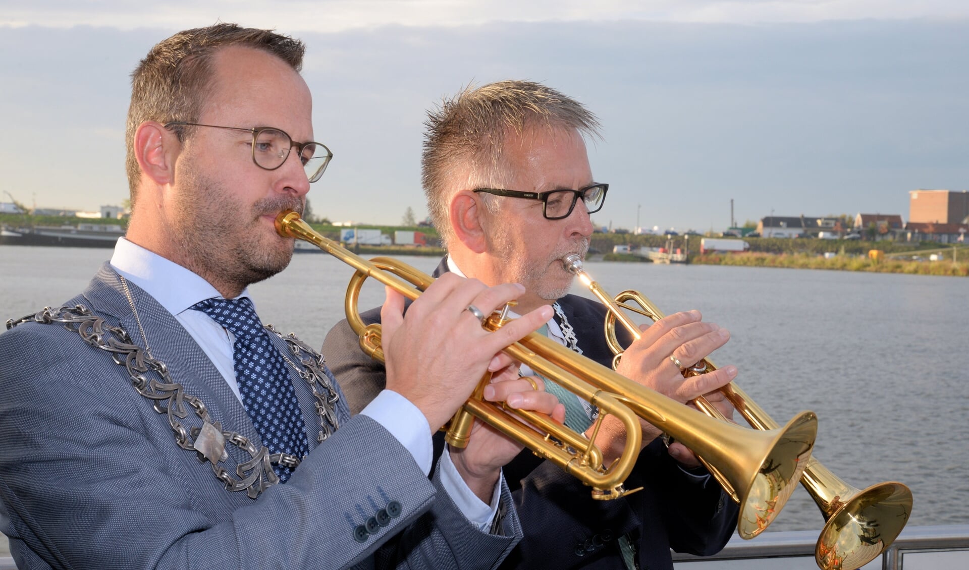 • Burgemeester Laurens de Graaf van Lopik (links) en de Zederikse locoburgemeester Maks van Middelkoop maken samen muziek op de Lek.