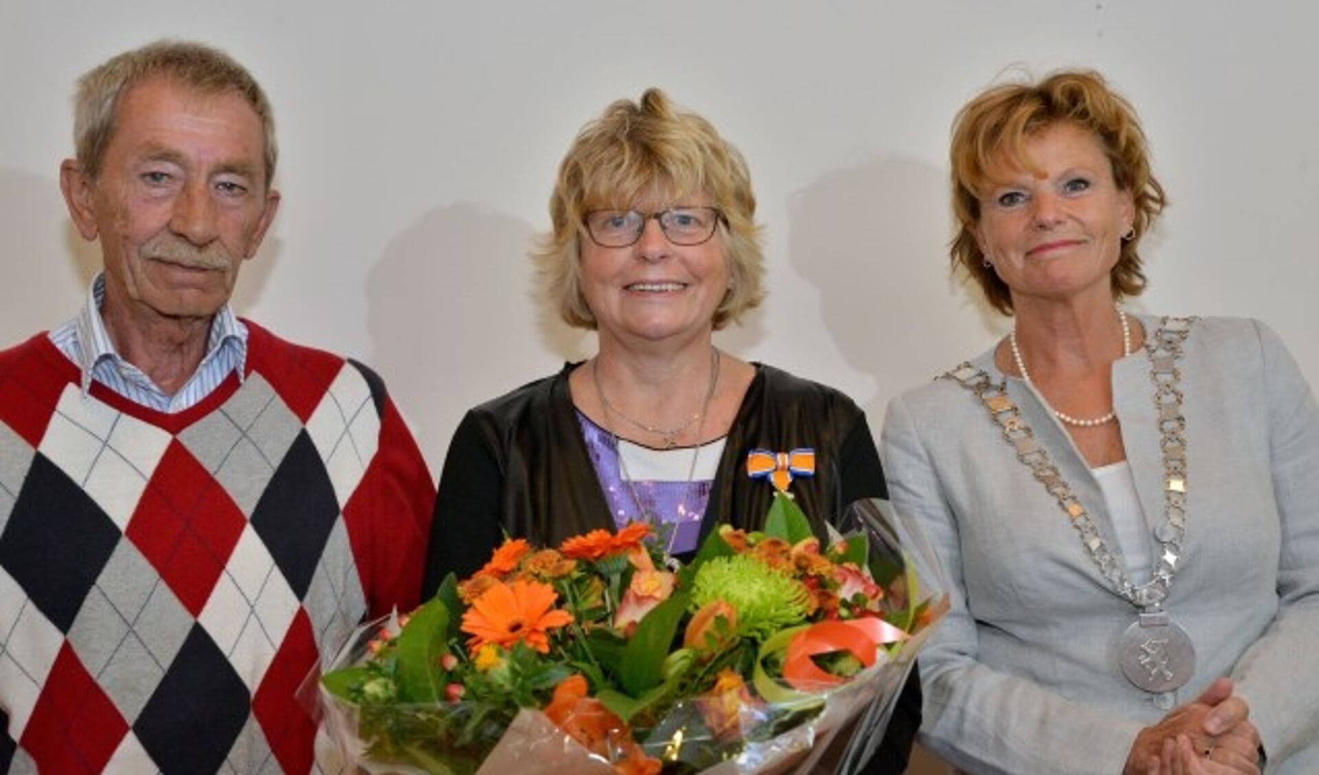 Een volledig verraste Mia van Jaarsveld-Kemp, geflankeerd door haar echtgenoot en burgemeester Petra van Hartskamp, ontving zondagmorgen een Koninklijk onderscheiding . (Foto: Paul van den Dungen)
