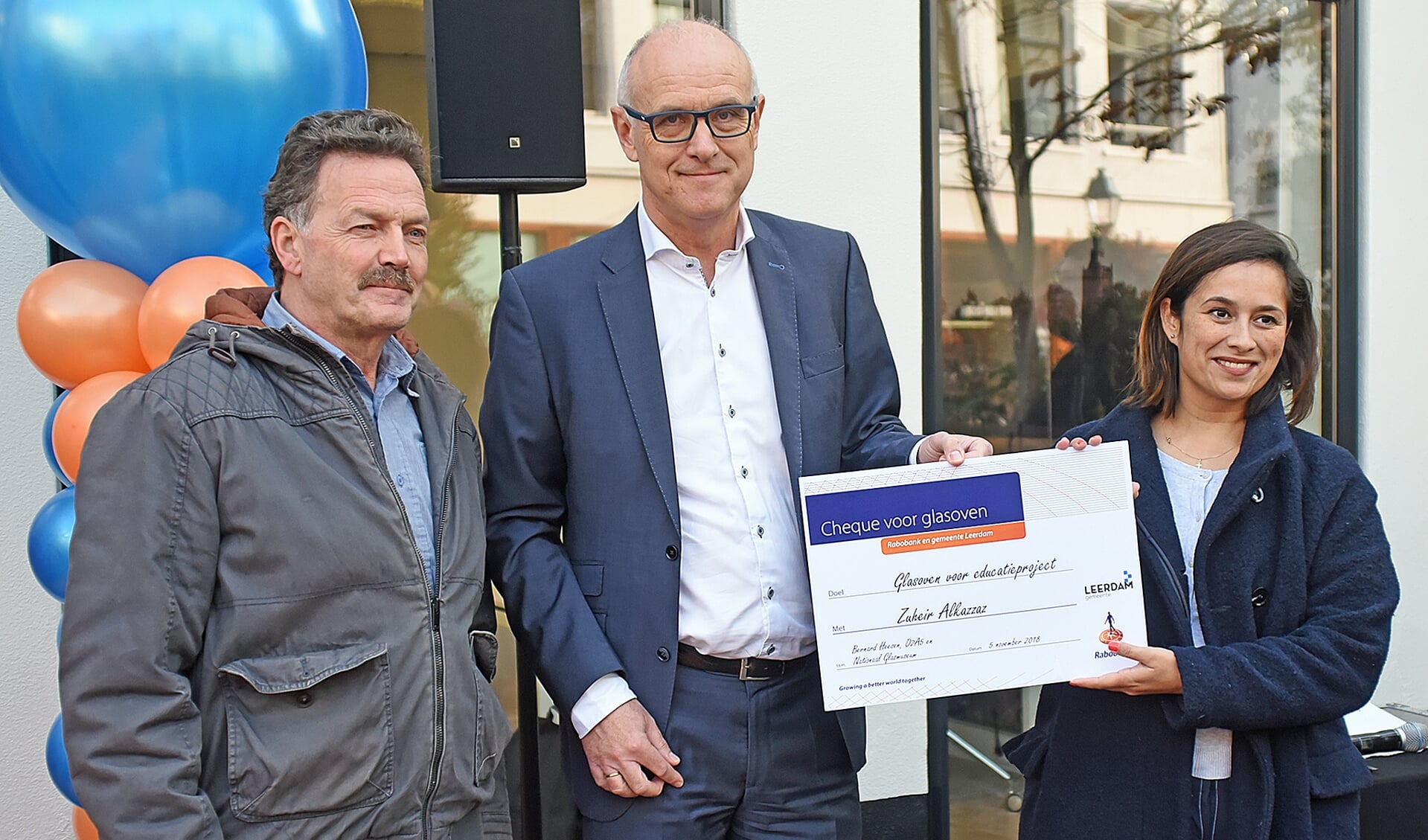 • Teus Meijdam en Martijn Spijk overhandigen de cheque aan Sacha Kraan.