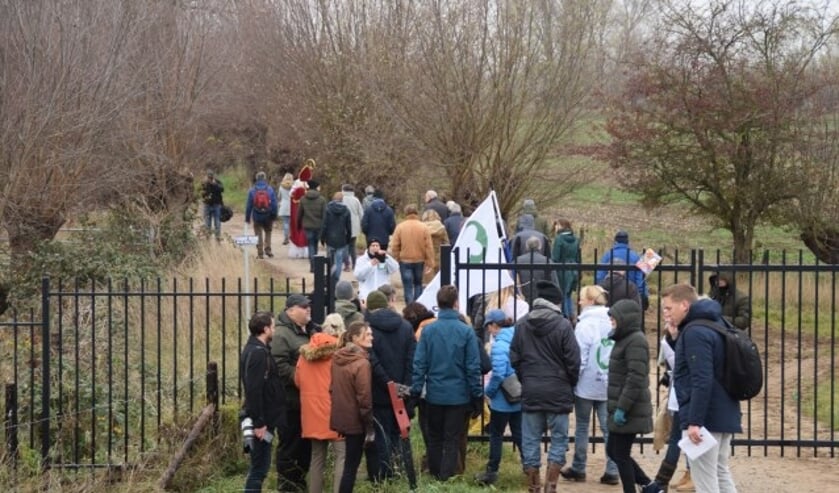 Protestanten van Collectief Redichemse Waard 'breken' het hek door met Sinterklaas voorop.  