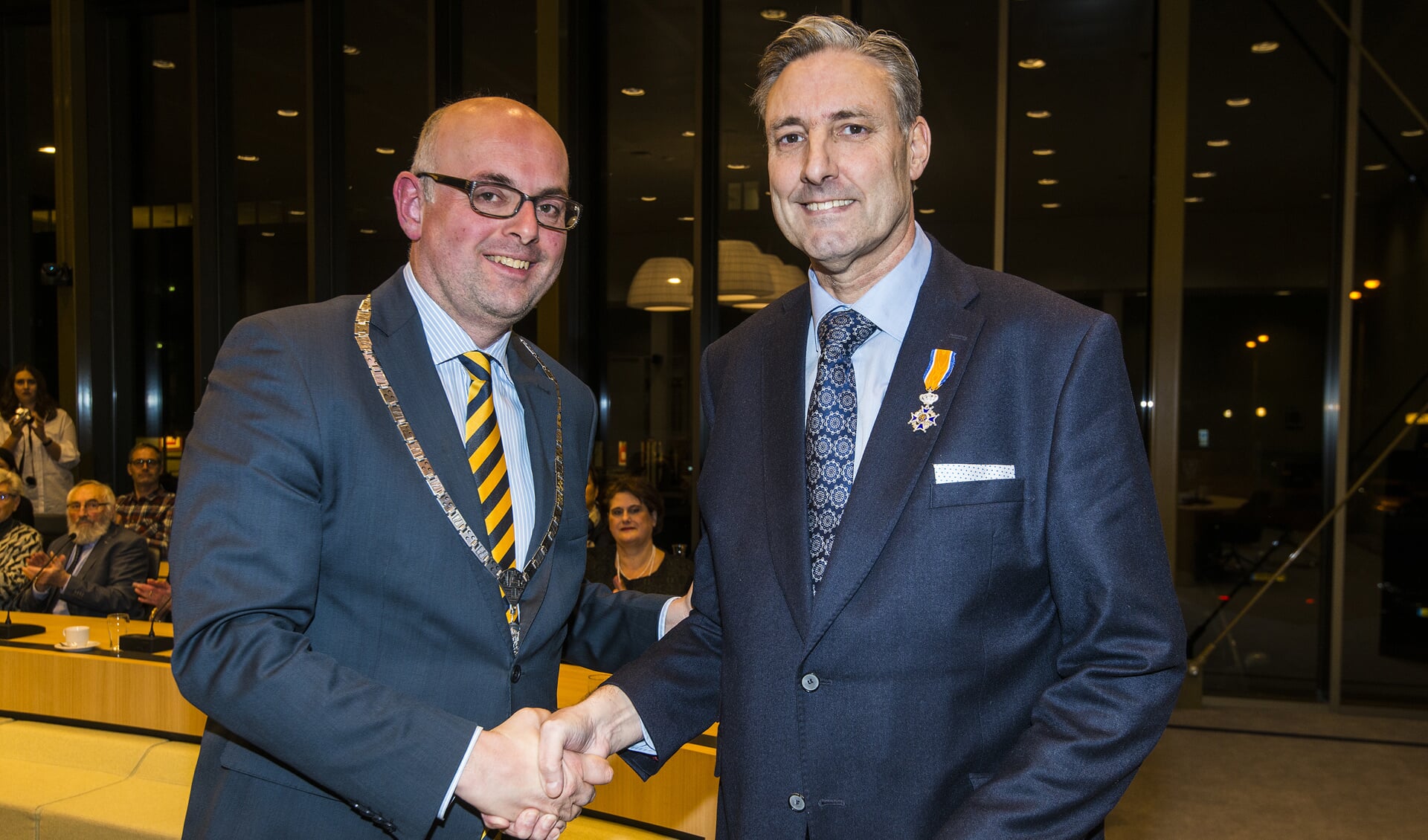 • Burgemeester Martijn Vroom met Hans Butter (rechts), net na de uitreiking van de koninklijke onderscheiding.